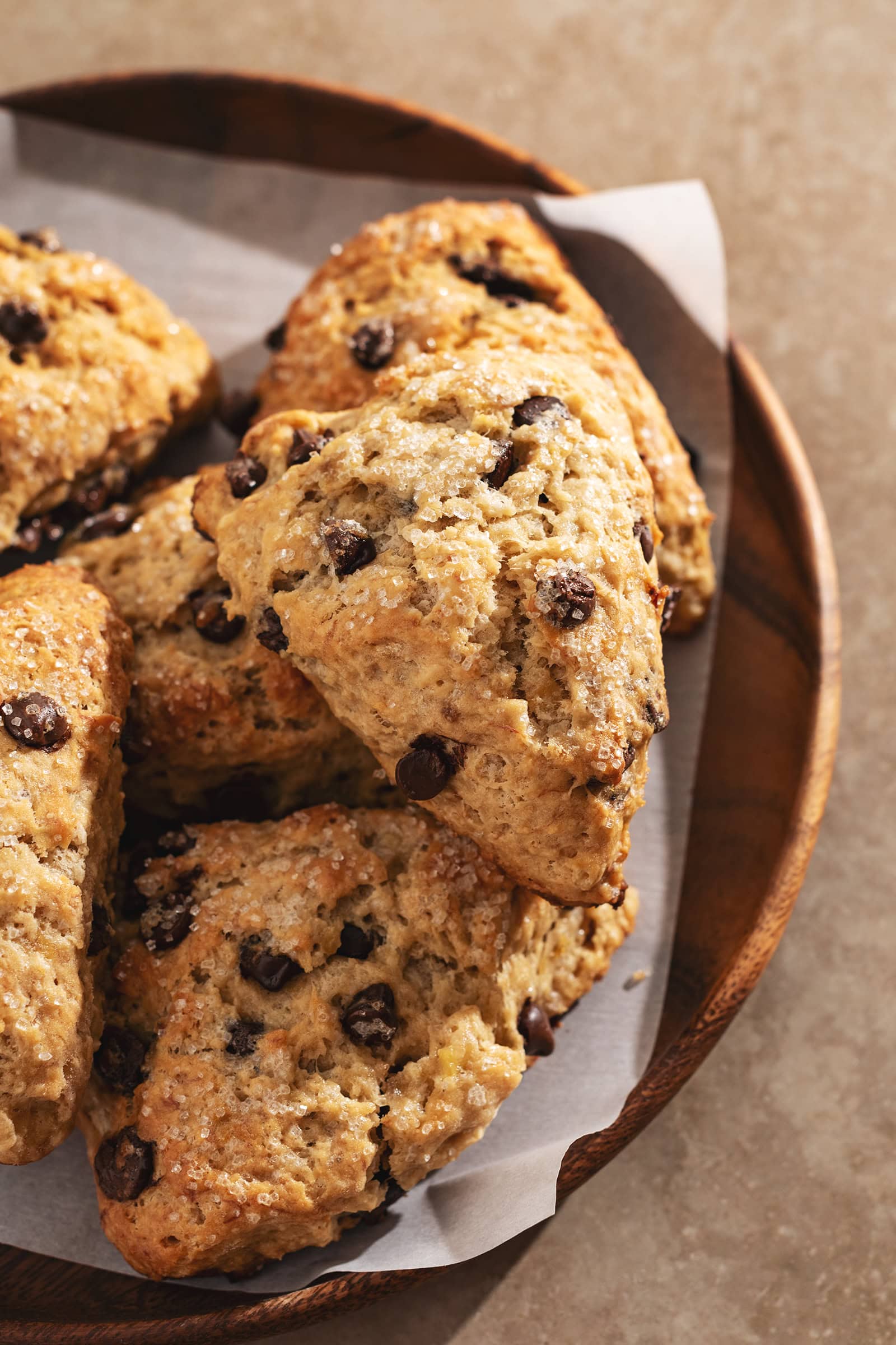 Banana chocolate chip scones piled on a wooden tray.
