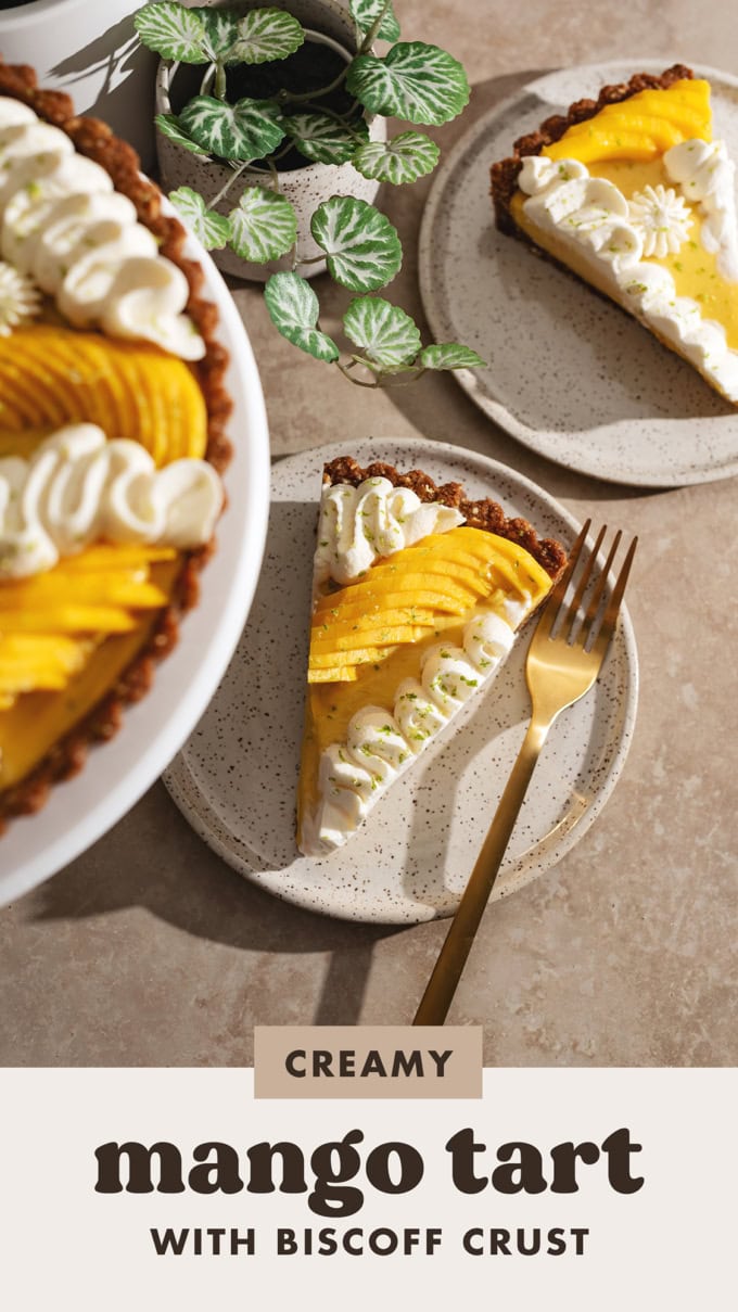 Two mango tart slices on plates with the rest of the tart blurred in the foreground.