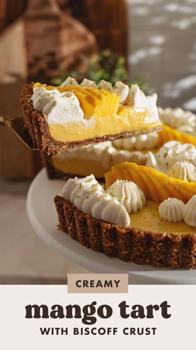 A slice of mango tart lifted from the rest of the tart with a cake server to show the cross-section view inside.