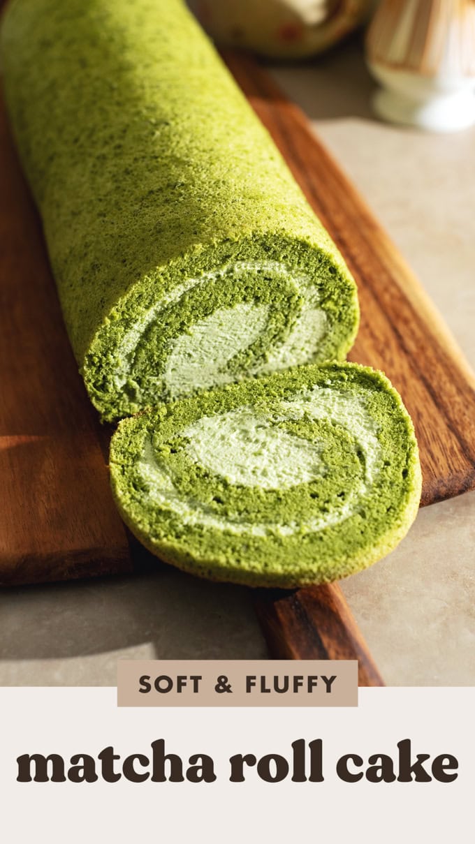 A slice cut from a matcha roll cake laying in front of the rest of the cake.