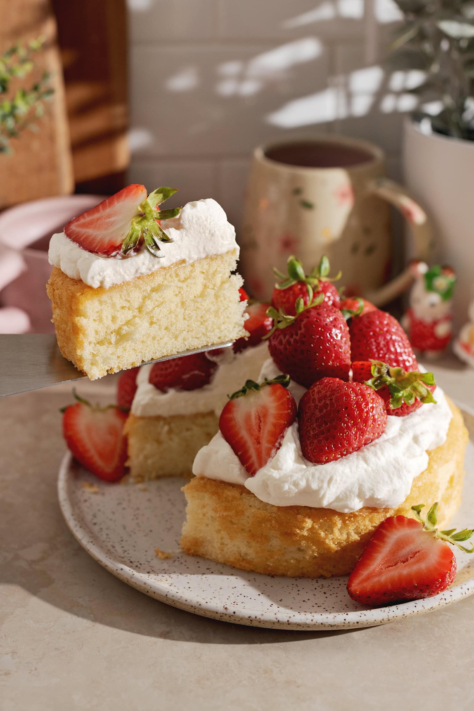 A slice of cake lifted from the rest of the cake with a cake server.