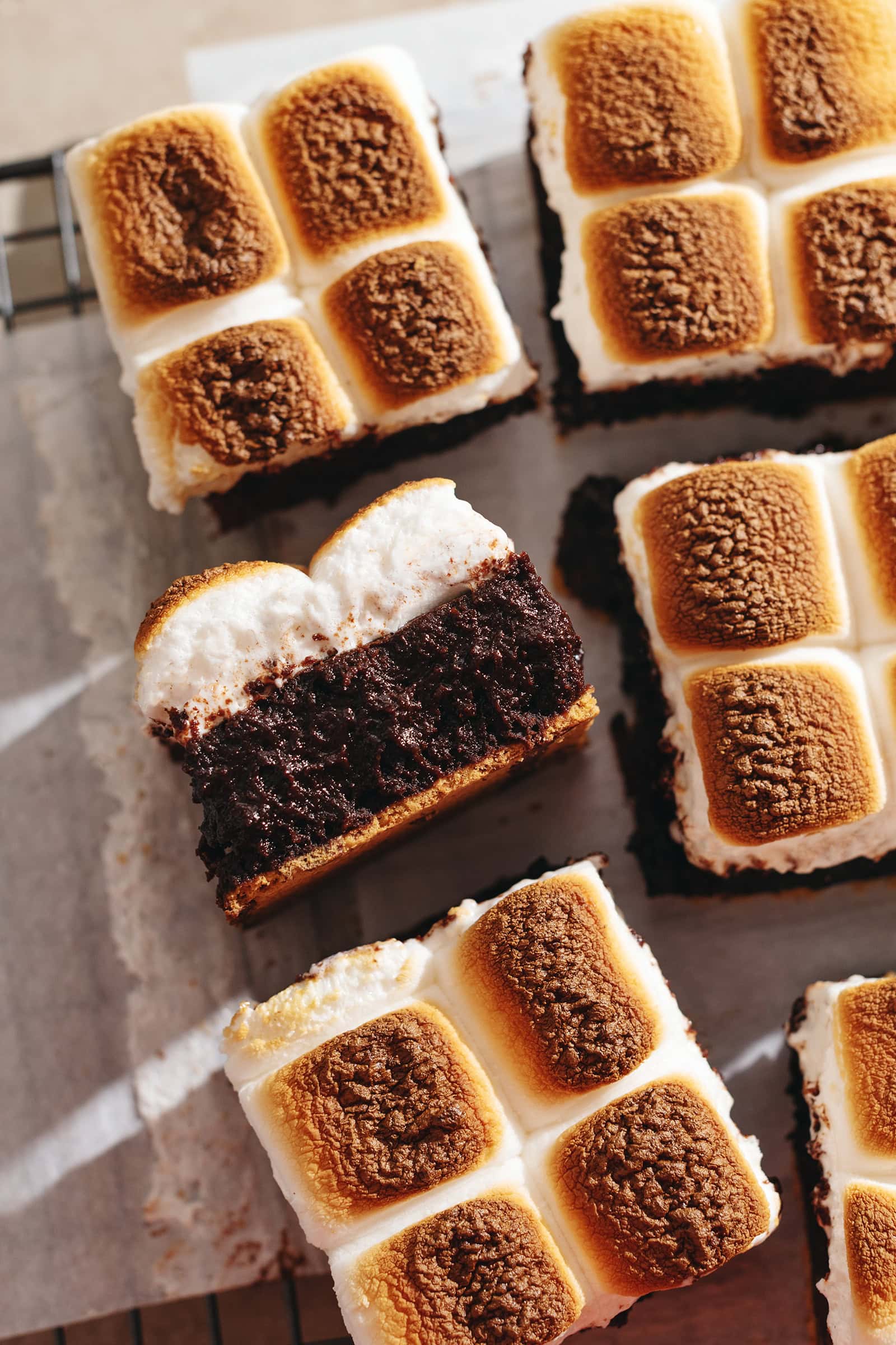 A s'mores brownie laying on its side to show the layers of graham cracker, brownie, and marshmallow.