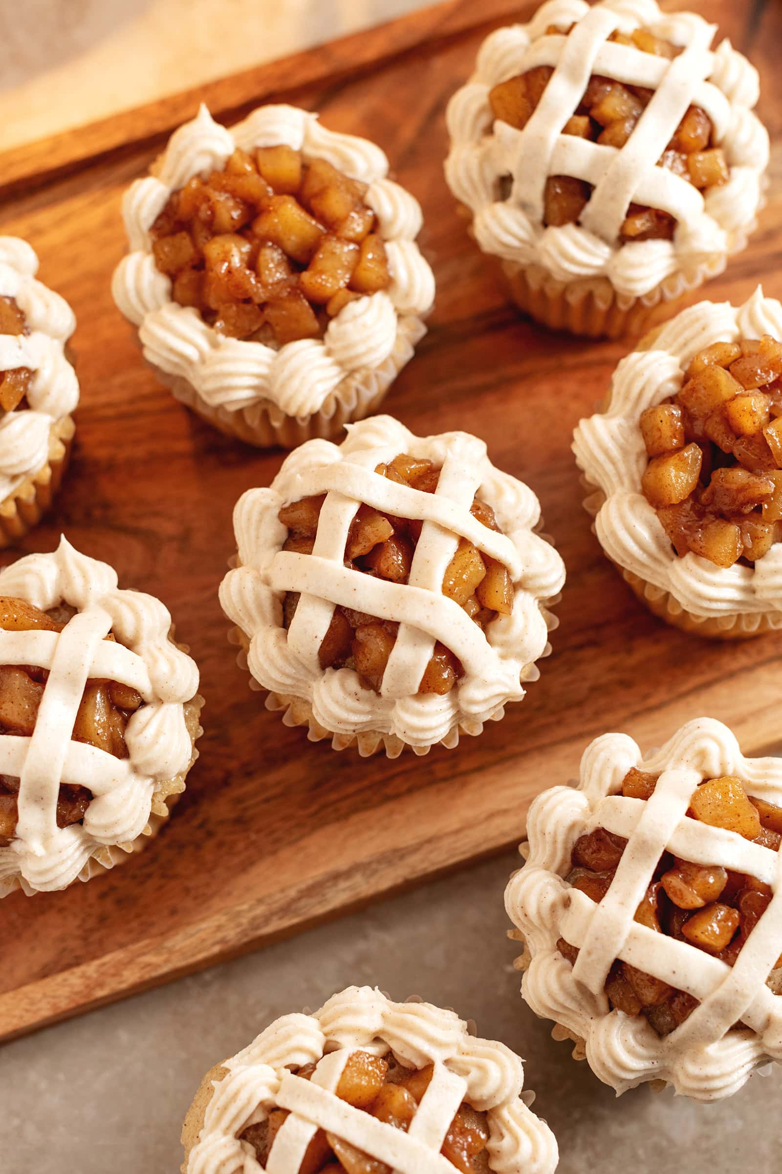 Top down view of several apple pie cupcakes showing the pie lattice frosting design on top.