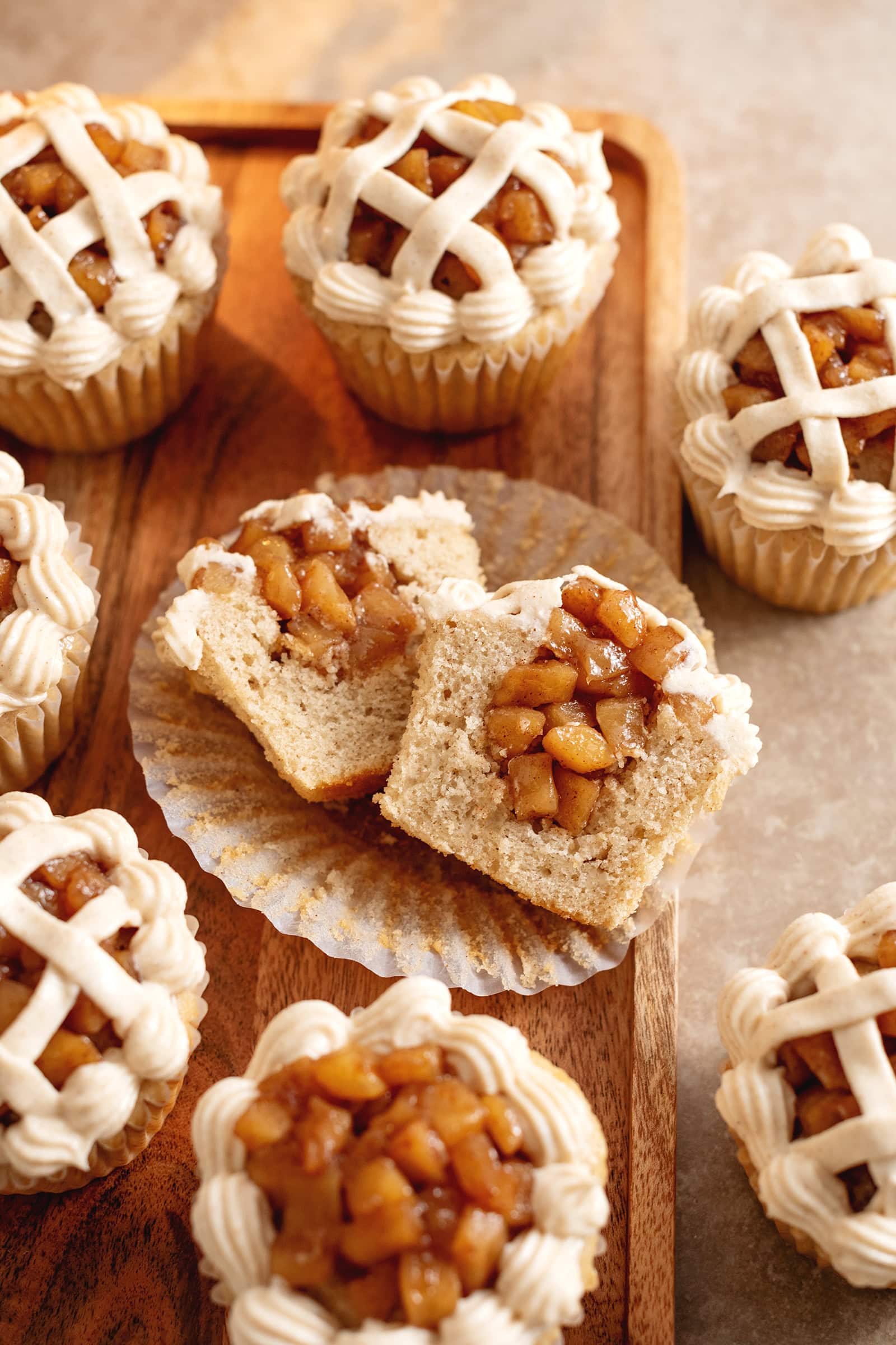 An apple pie cupcake cut in half to show the apple compote filling inside.
