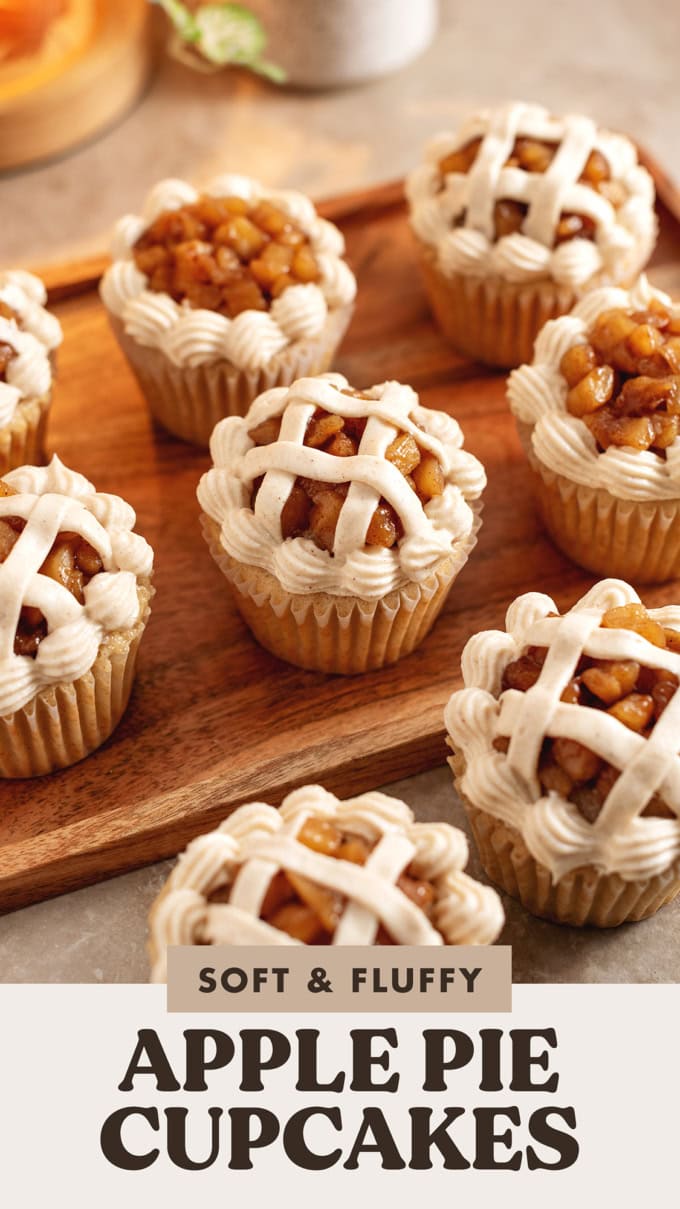 Several apple pie cupcakes decorated like a pie lattice scattered on a wooden tray.
