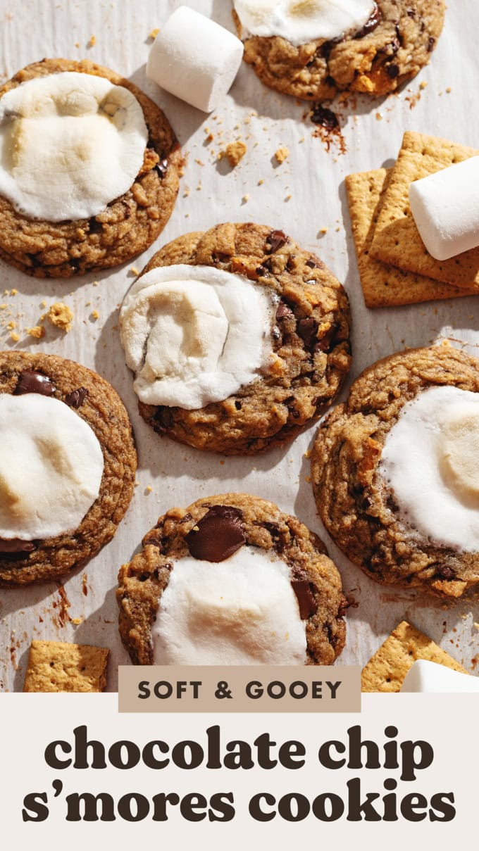 Several chocolate chip s'mores cookies scattered on parchment paper.