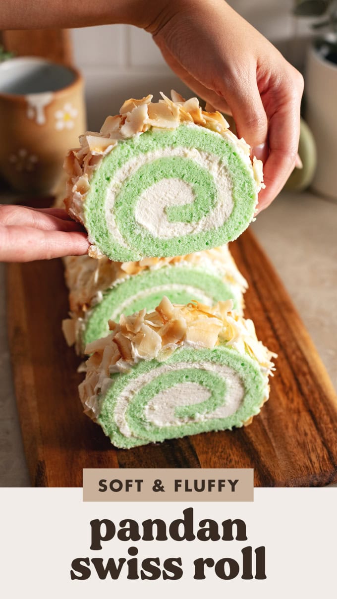 Hands lifting a slice of pandan swiss roll above the rest of the roll cake.