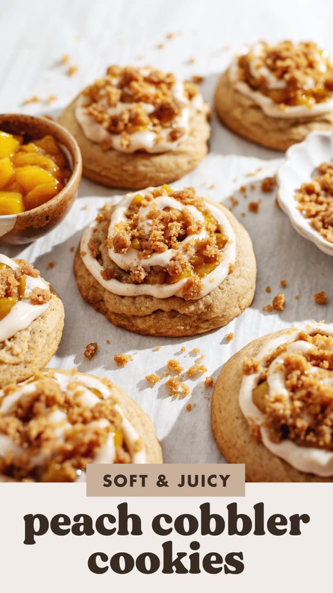 Side view of a peach cobbler cookie with a swirl of cream cheese on top surrounded by more cookies.