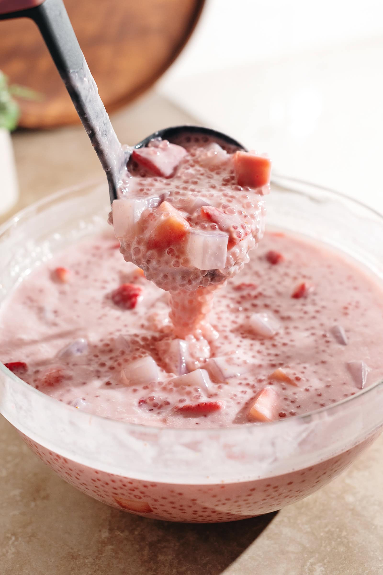 A ladle of strawberry sago dripping back into the bowl.