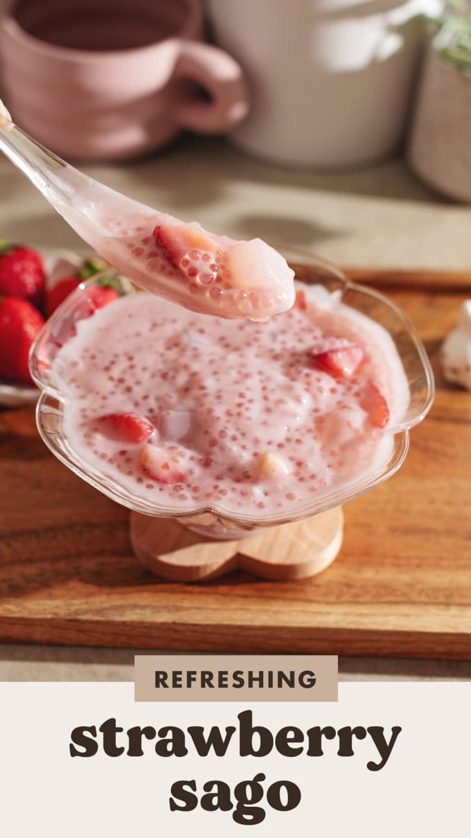 A spoonful of strawberry sago lifted above a bowl.