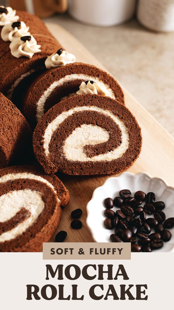 Slices of mocha roll cake arranged on a wooden platter with coffee beans in front of them.