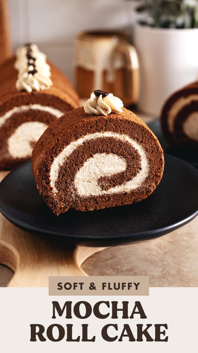A slice of mocha roll cake on a black plate.