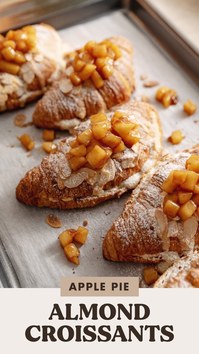 Apple pie almond croissants topped with apple pie filling on a baking tray.