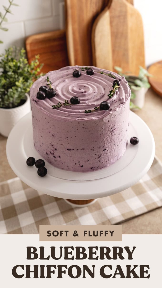 A whole blueberry chiffon cake on a cake stand.