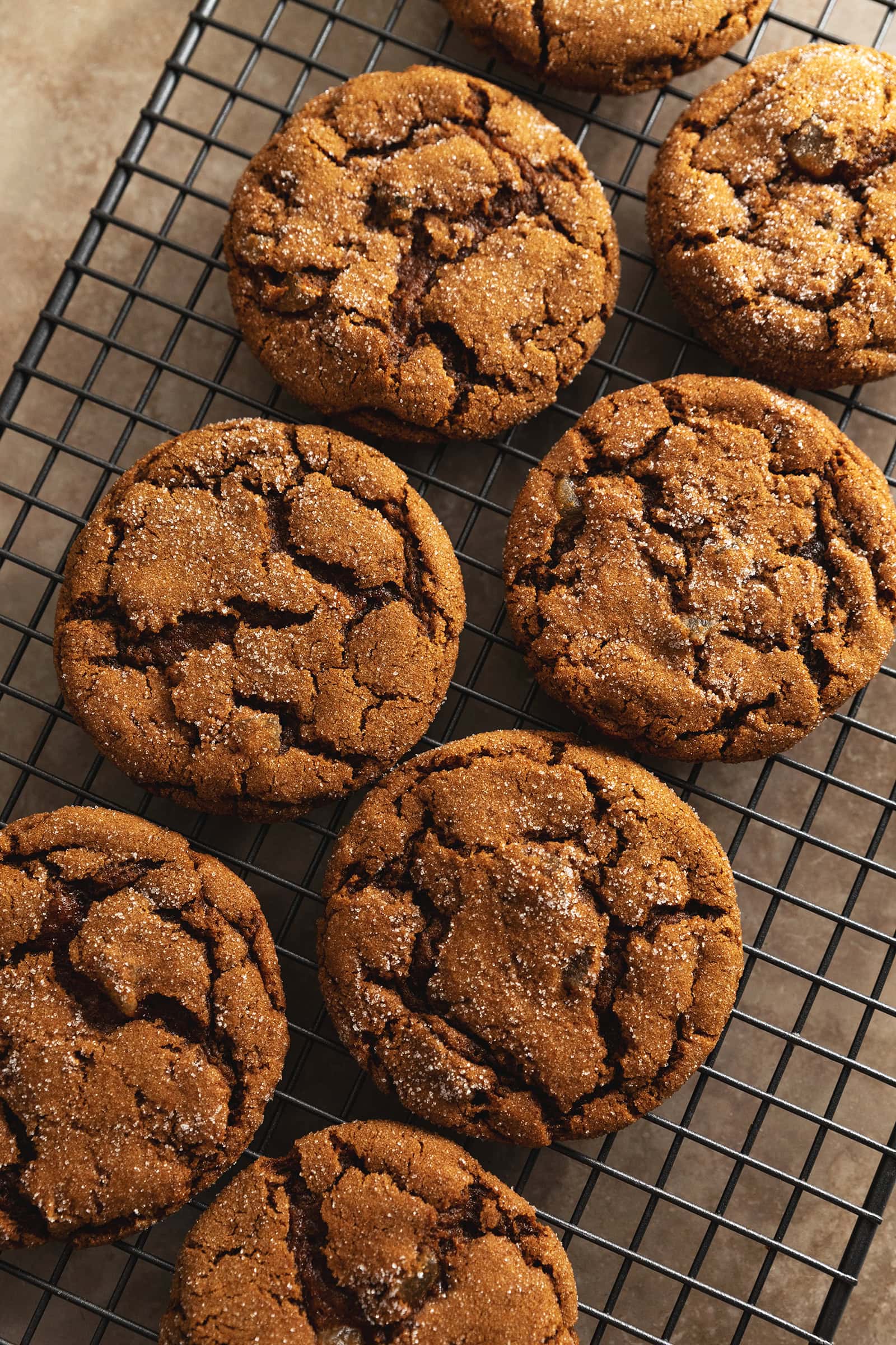 Chewy ginger cookies lined up on a wire rack.