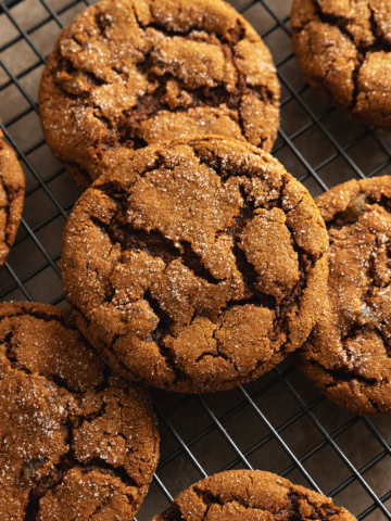Chewy ginger cookies scattered on a wire rack.