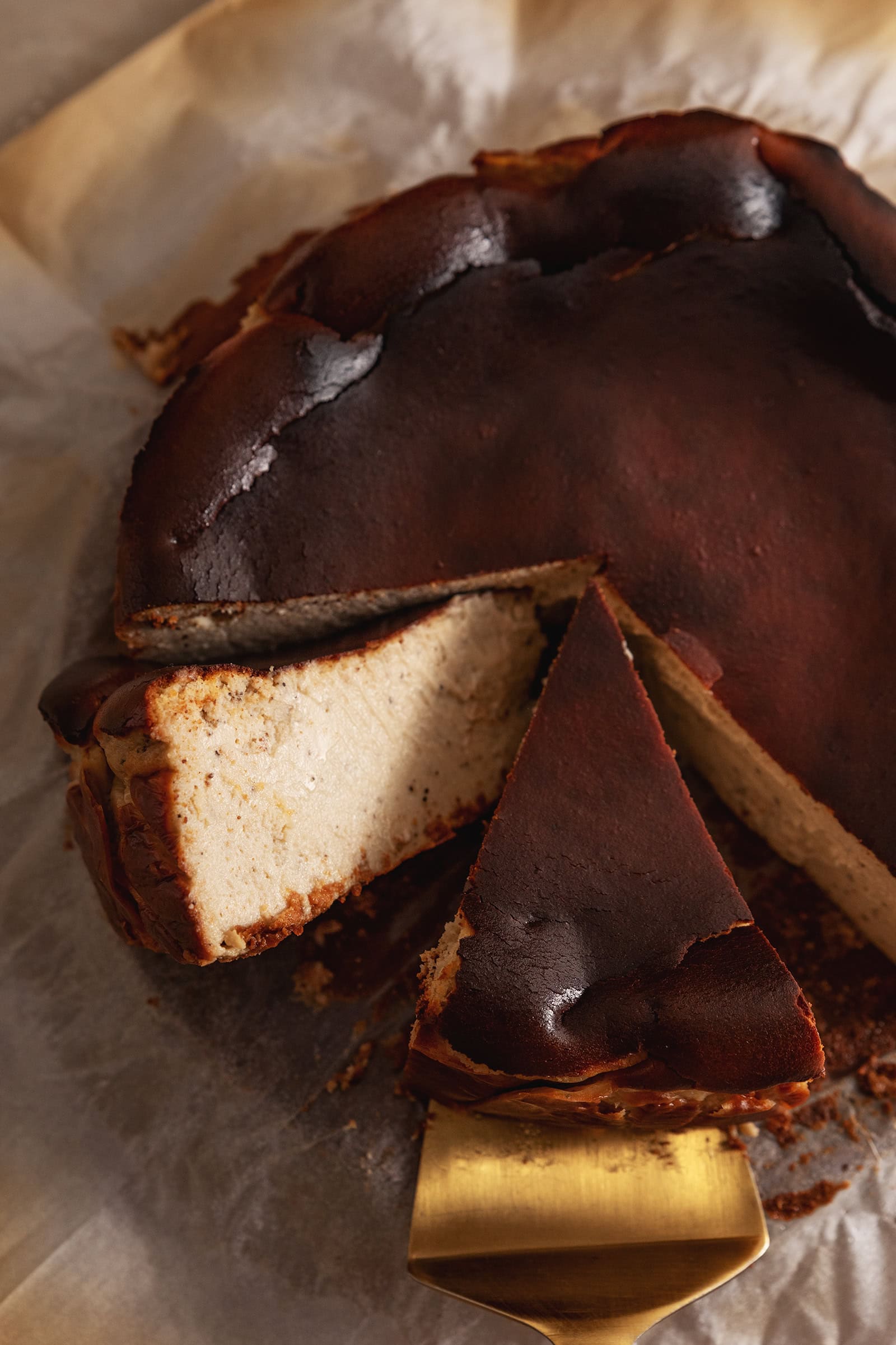 A slice of earl grey basque cheesecake laying on its side with another slice next to it.