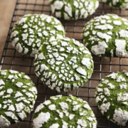 Matcha crinkle cookies scattered on a wire rack.