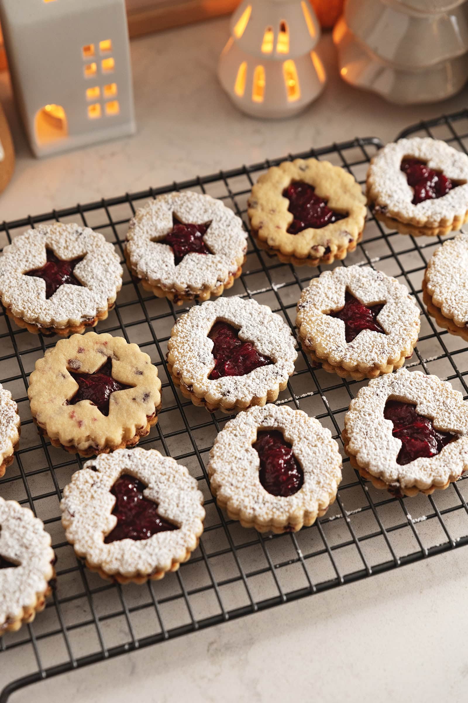 Cranberry linzer cookies lined up on a wire rack.