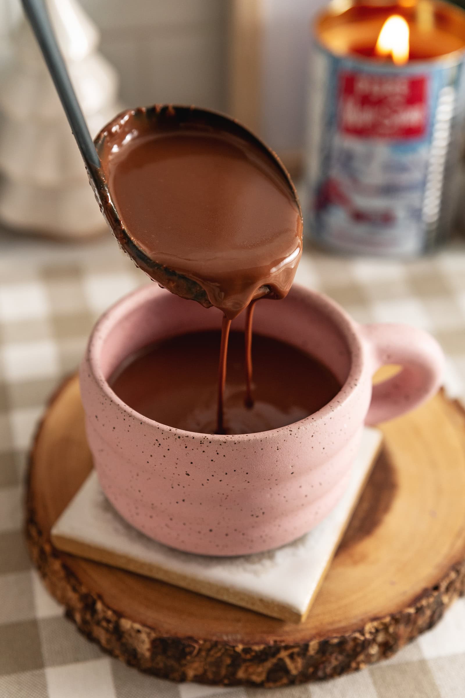 A ladle of earl grey hot chocolate being poured into a mug.
