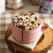 A mug of earl grey hot chocolate with toasted marshmallows on top and a drip down the side of the mug.