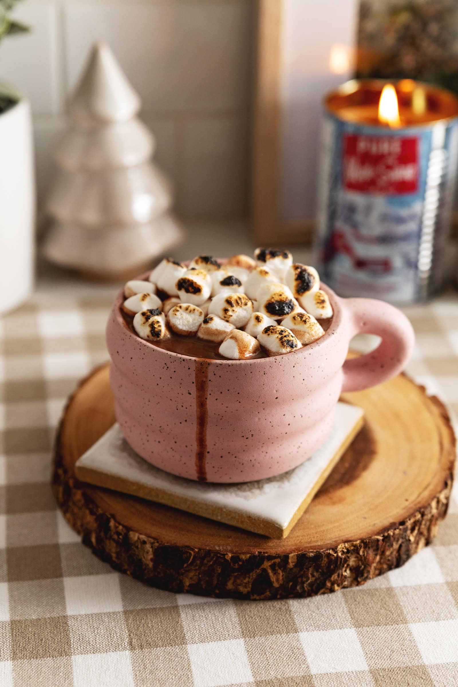A mug of earl grey hot chocolate with toasted marshmallows on top and a drip down the side of the mug.