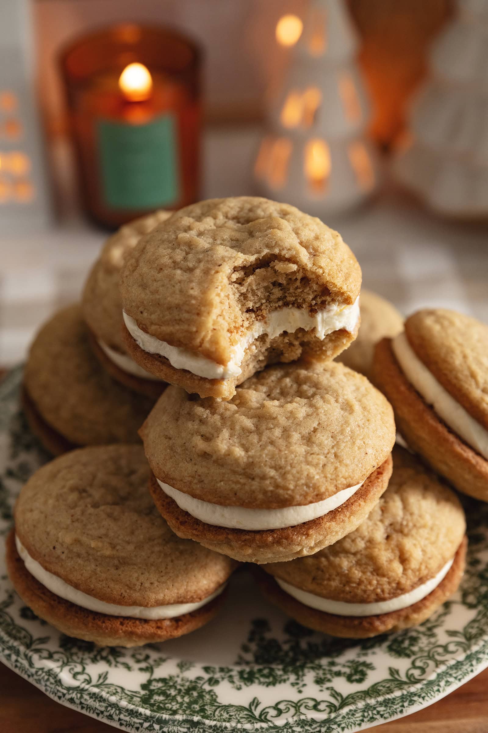 A stack of eggnog sandwich cookies with a bite taken out of the cookie on top.