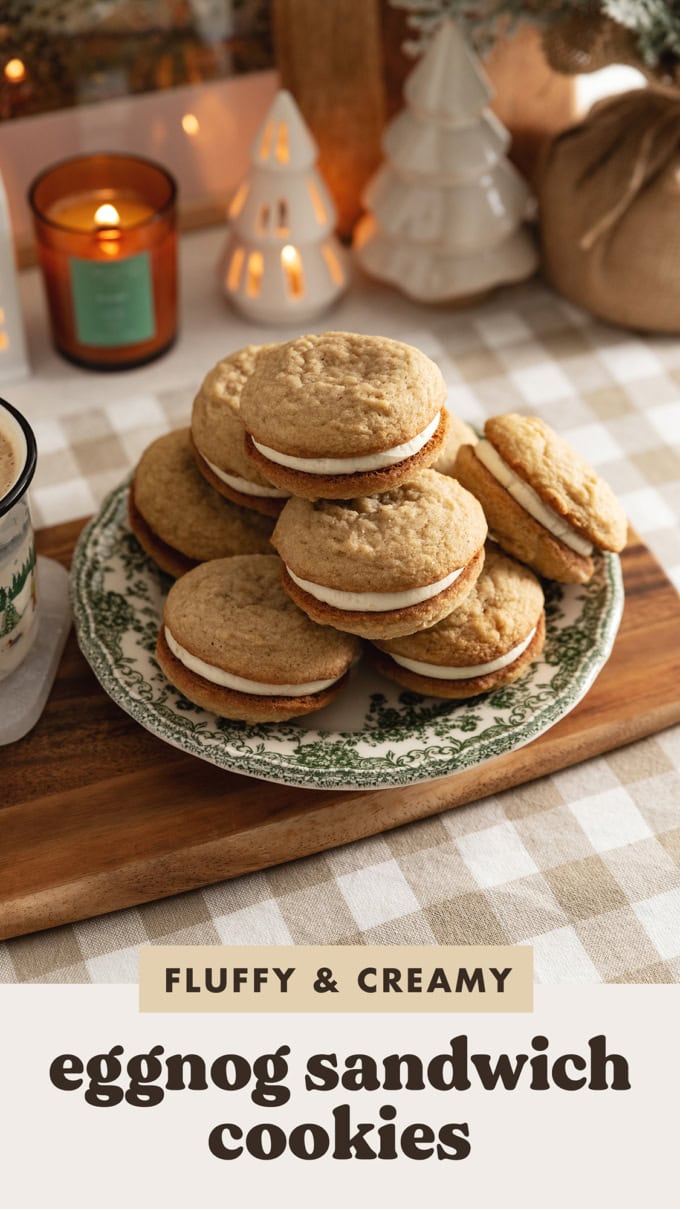 Eggnog sandwich cookies piled up on a plate on a kitchen counter.