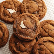 Gingerbread cheesecake cookies scattered on a counter.