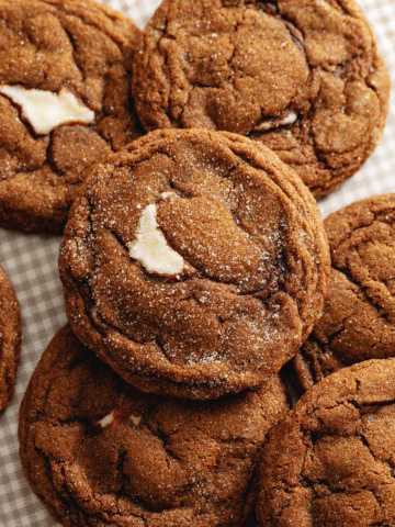 Gingerbread cheesecake cookies scattered on a counter.