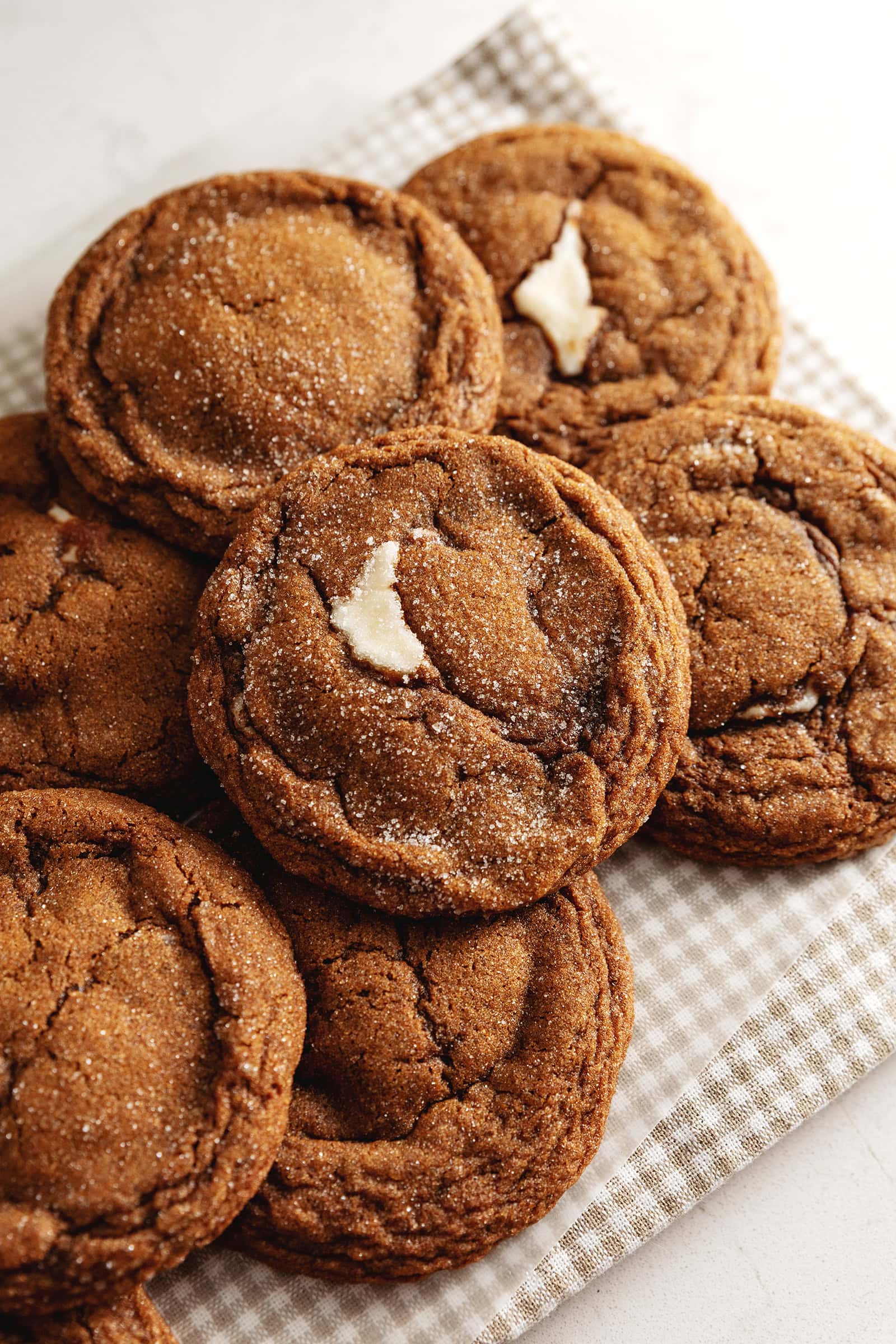 Gingerbread cheesecake cookies piled on a counter.