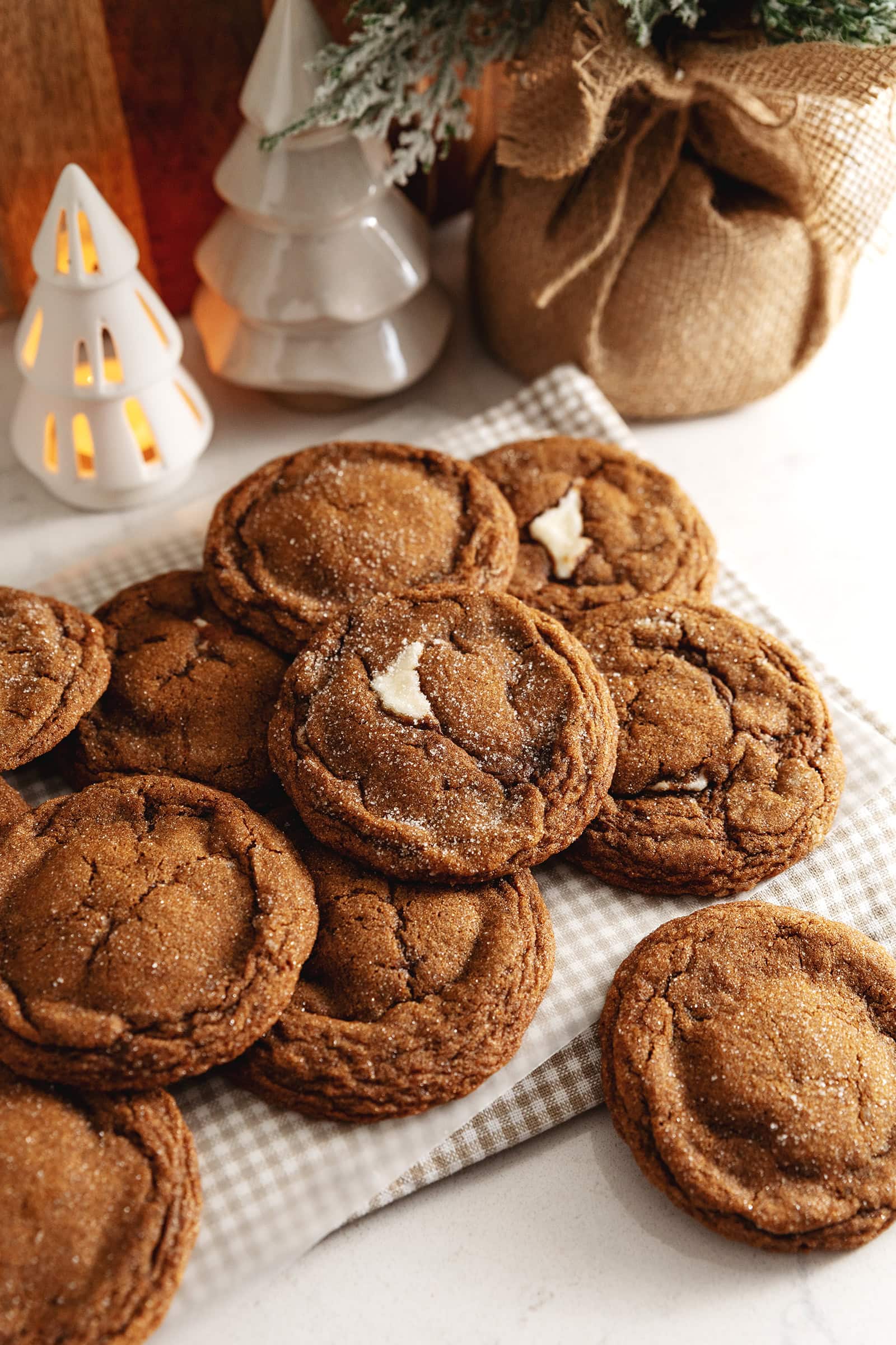 Gingerbread cheesecake cookies piled on a kitchen counter.