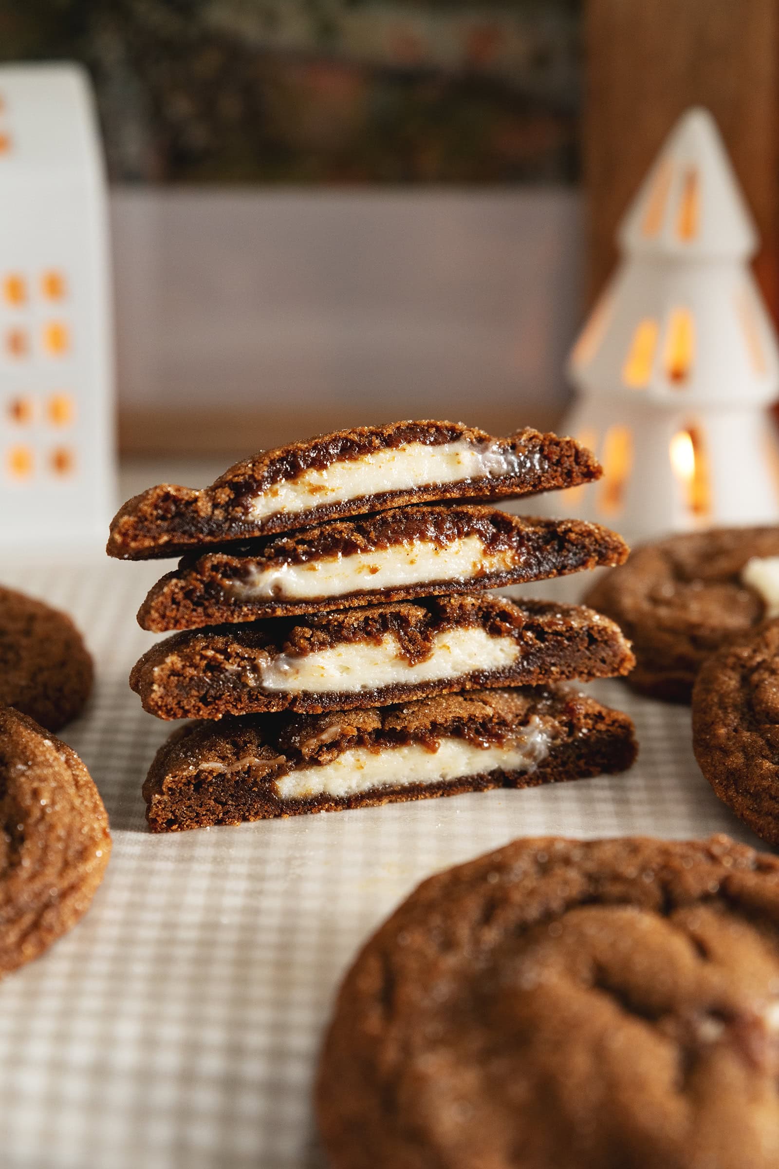A stack of gingerbread cheesecake cookies cut in half to show the cheesecake filling inside.
