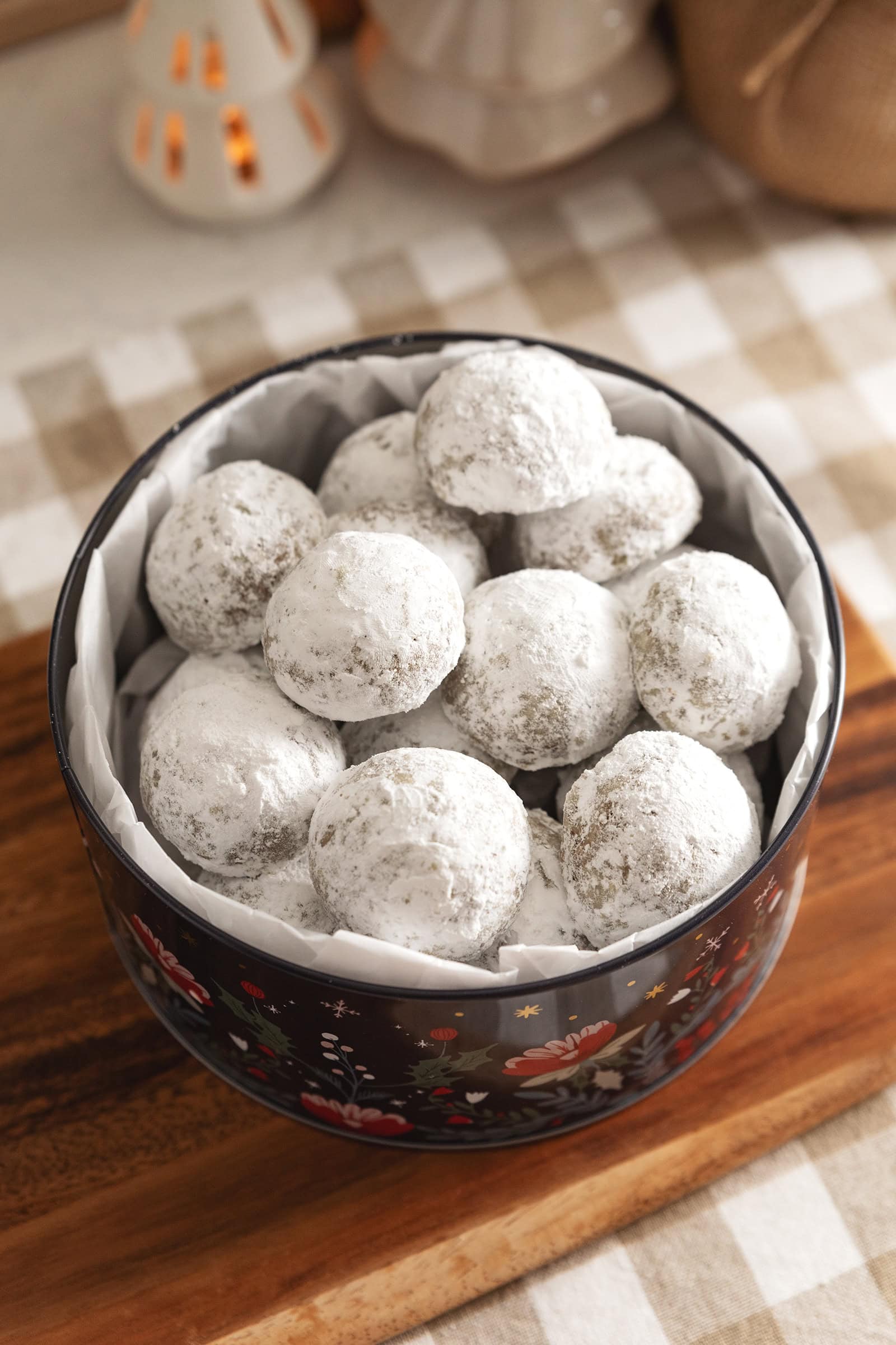 Hojicha snowball cookies piled in a cookie tin.