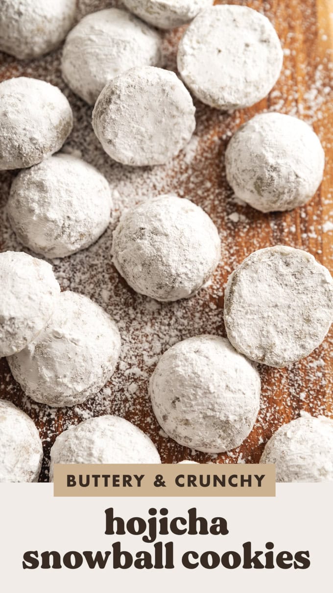 Hojicha snowball cookies dusted with powdered sugar on a wooden board.
