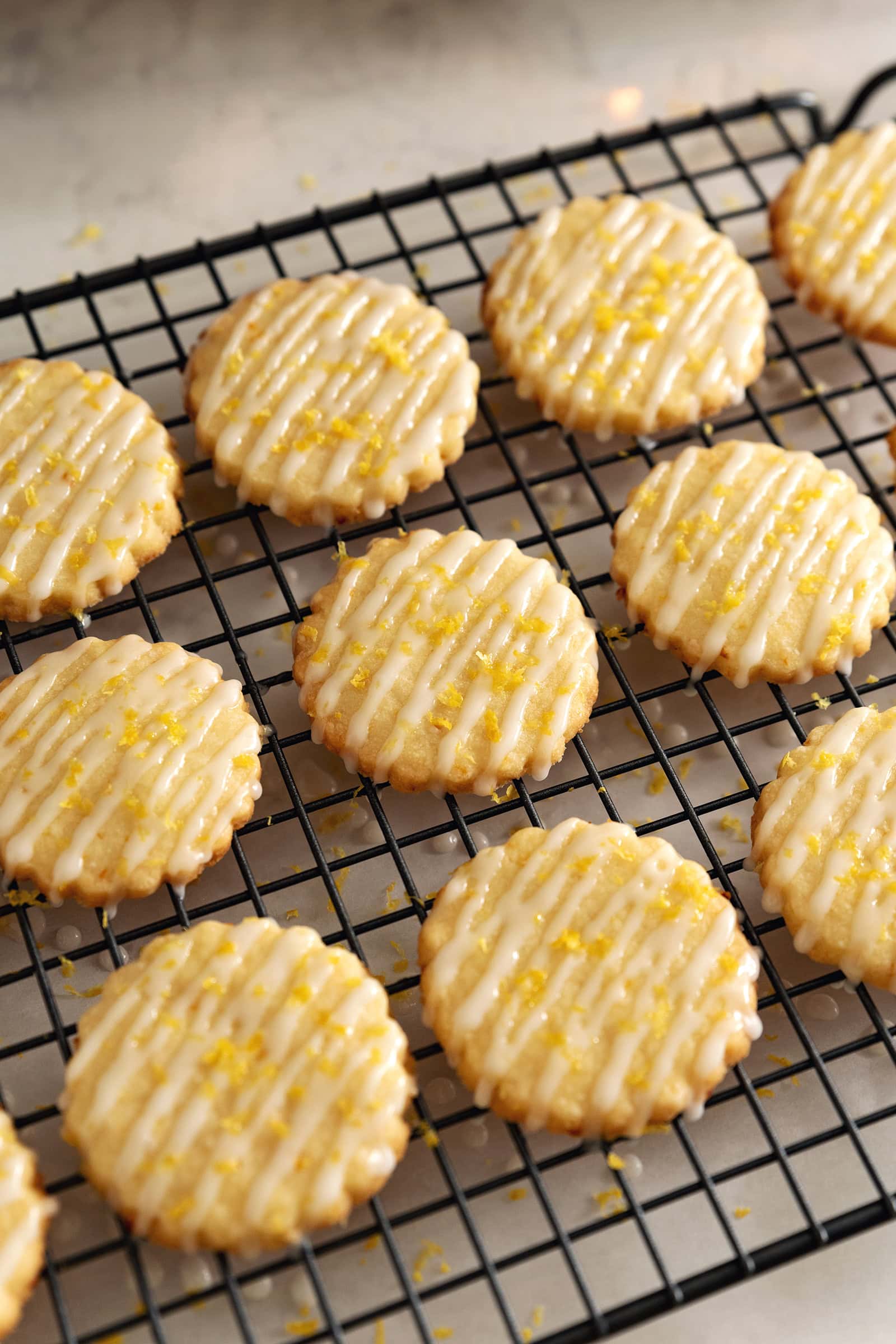 Lemon shortbread cookies lined up on a wire rack with drizzles of icing on top.