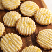 Lemon shortbread cookies scattered on a wooden platter.