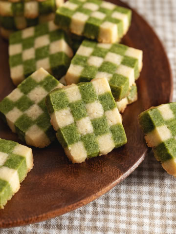 Matcha checkerboard cookies piled on a plate.