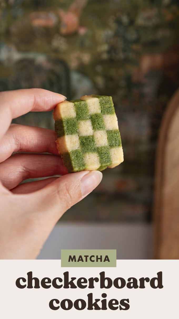 Hand holding a matcha checkerboard cookie to show the checkerboard pattern.