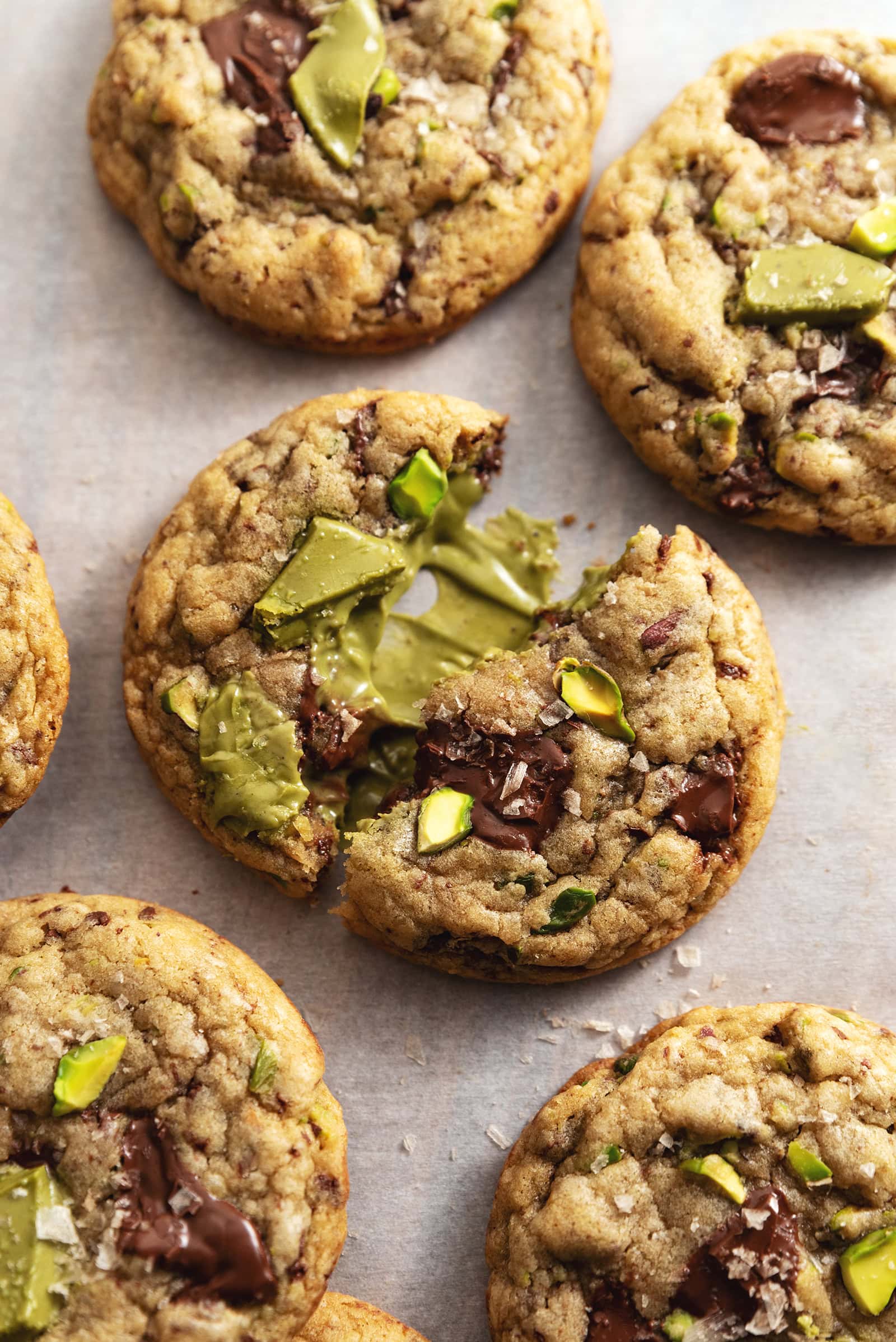 A pistachio cream cookie split in half to show the pistachio cream inside.