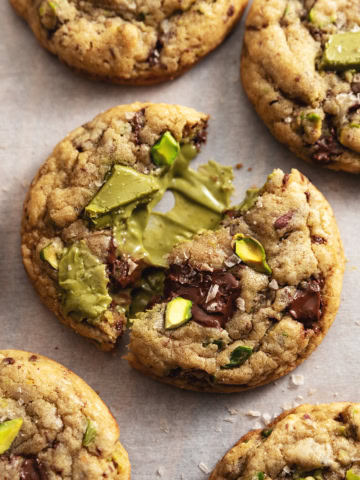 A pistachio cream cookie split in half to show the pistachio cream inside.