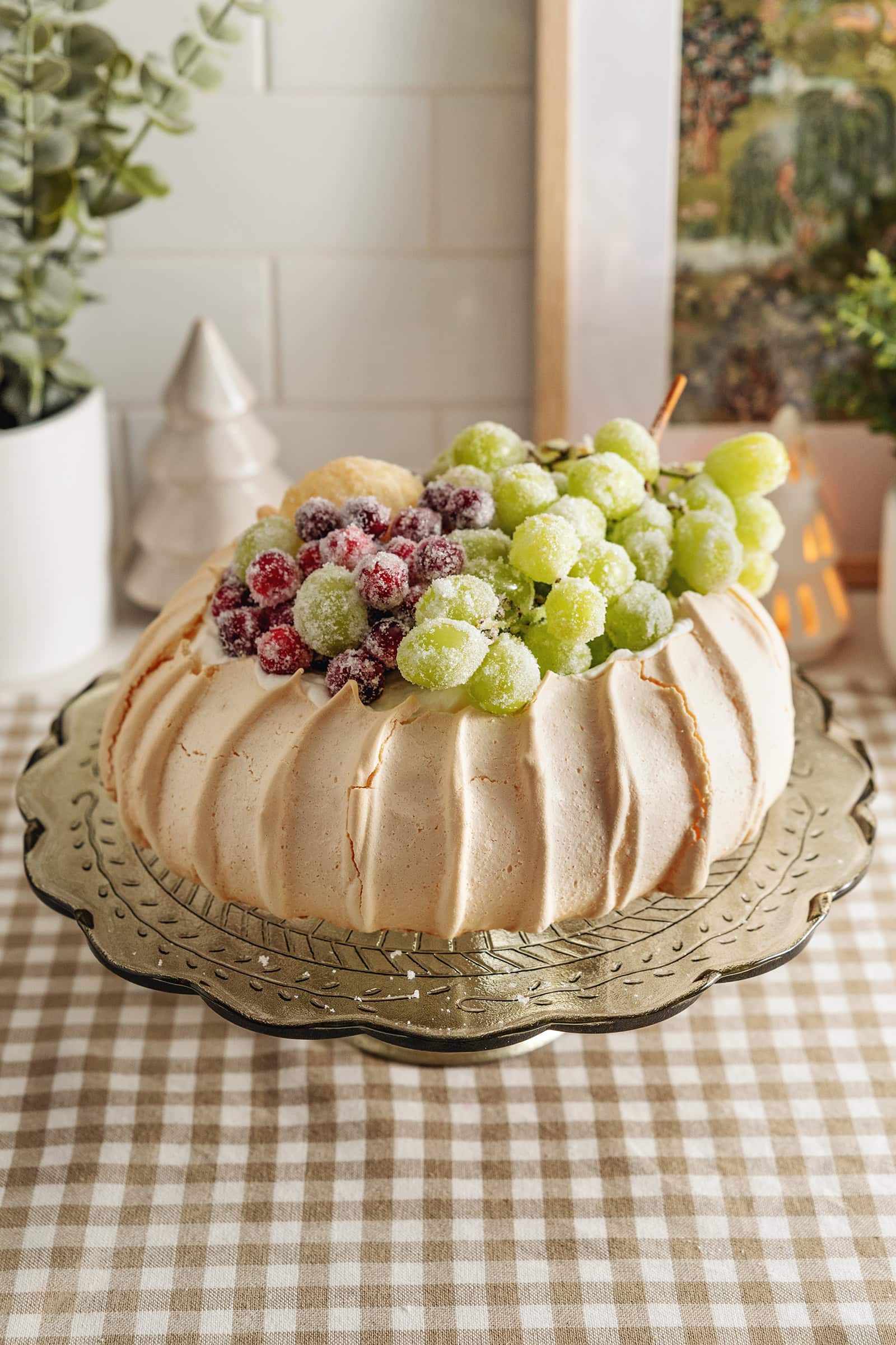 A sugared fruit pavlova on a cake stand.