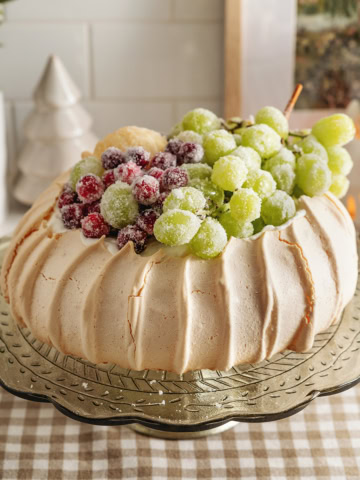 A sugared fruit pavlova on a cake stand.