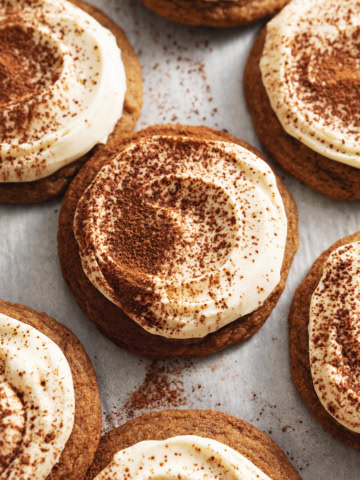 Overhead view of tiramisu cookies scattered on parchment paper.