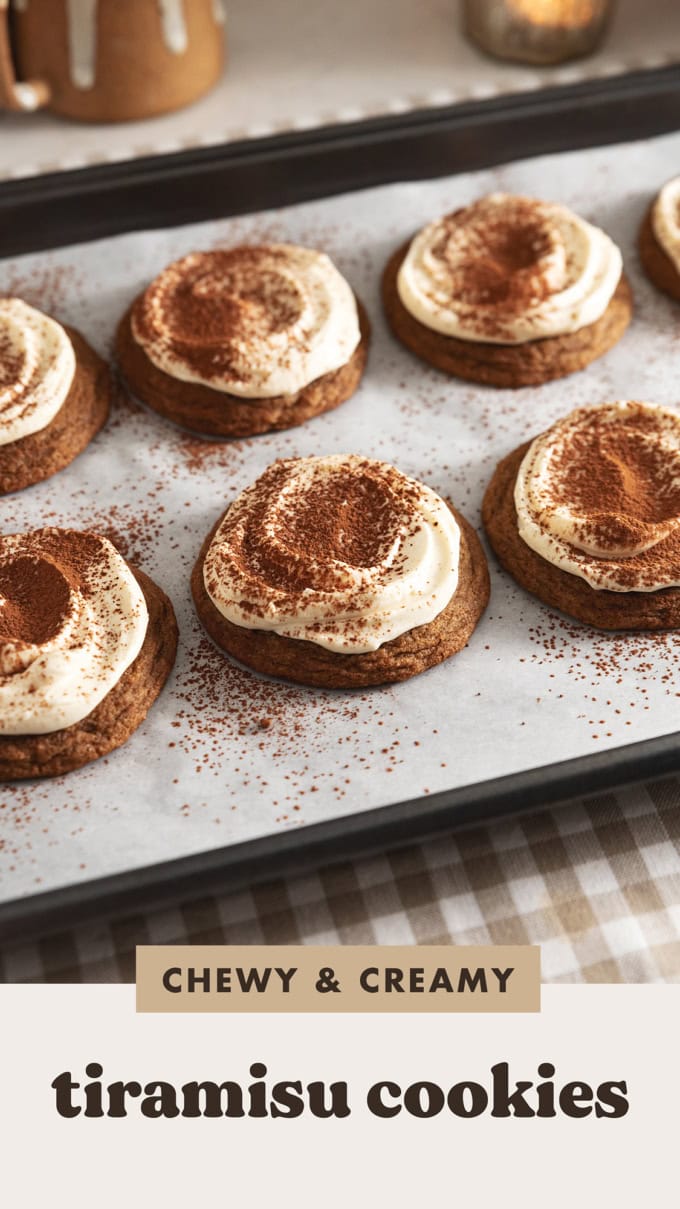 Tiramisu cookies dusted with cocoa powder and lined up on a baking tray.