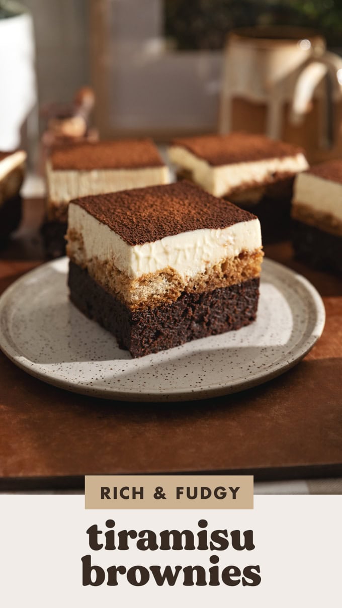 A tiramisu brownie on a speckled plate in front of other brownies.