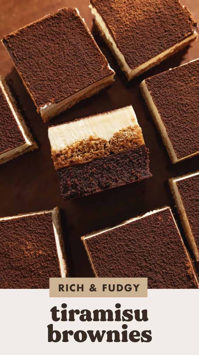 TIramisu brownies scattered on a wooden surface with one brownie laying on its side to show the layers.