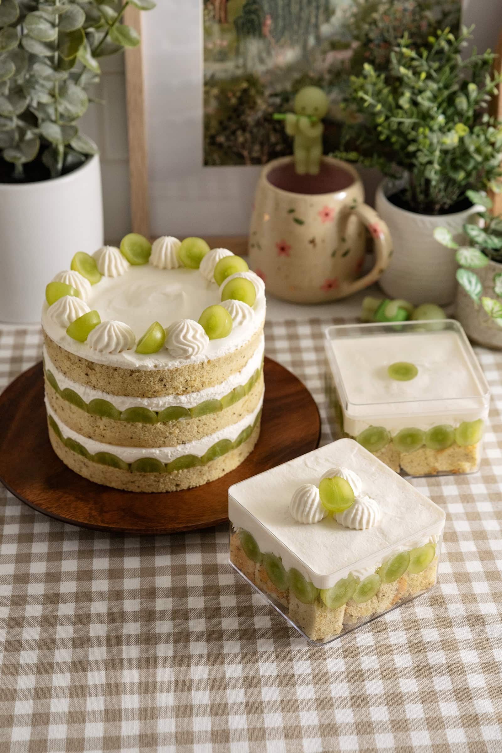 A jasmine green grape cake and two cake boxes on a kitchen counter.