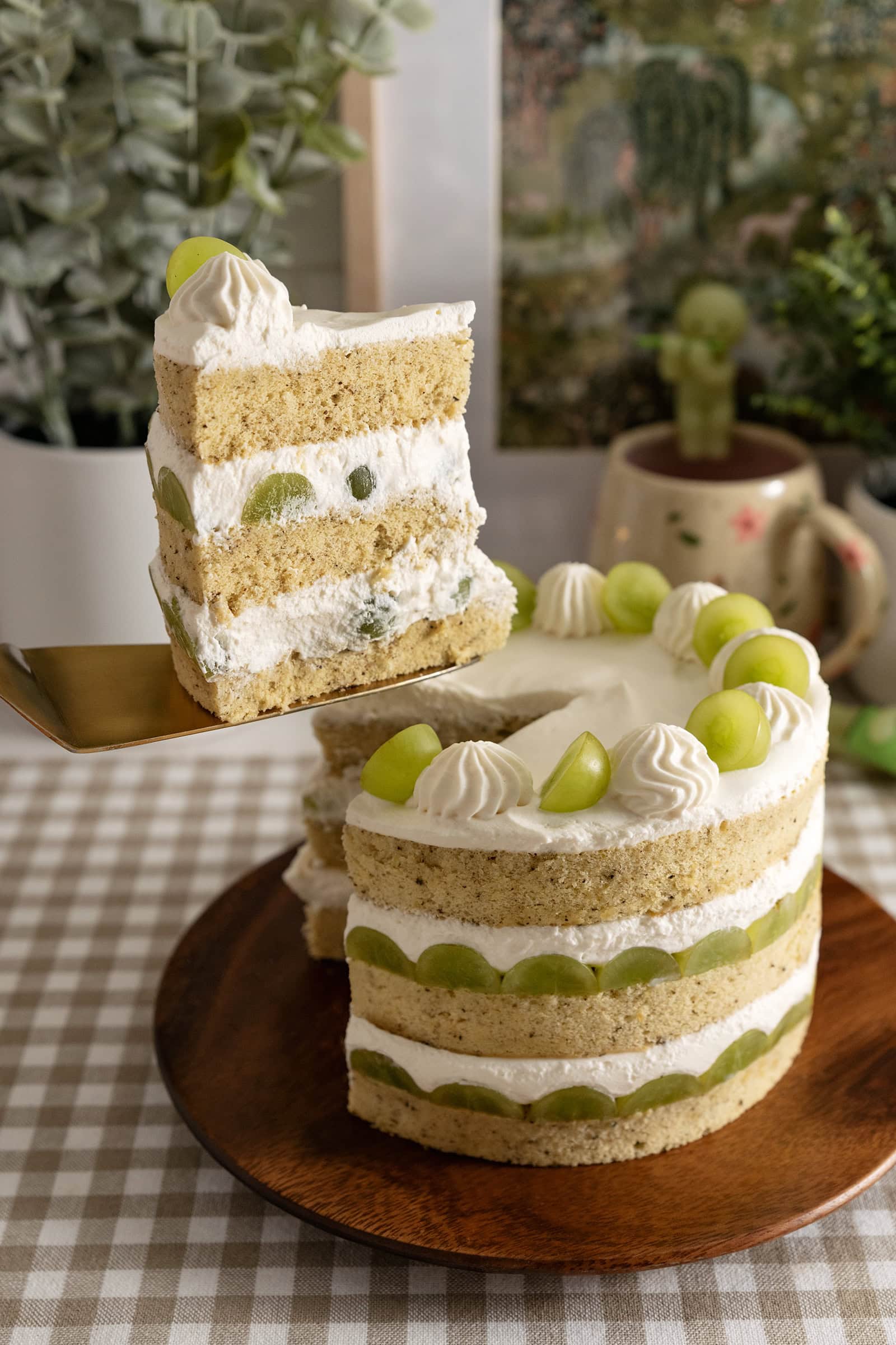 Lifting a slice of jasmine green grape cake above the rest of the cake.