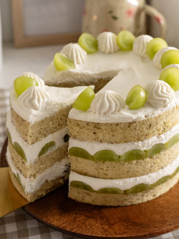 Pulling a slice of cake out of a jasmine green grape cake.